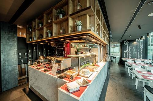 a restaurant with a counter with dishes and tables at Best Western Plus Net Tower Hotel Padova in Padova