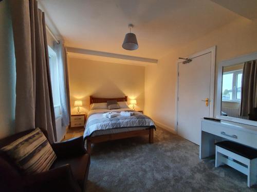 a bedroom with a bed and a chair and a window at The Bowers Bar & Restaurant in Ballinrobe