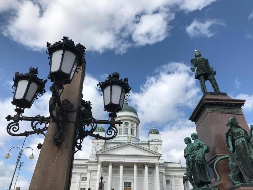 a street light in front of a building with a statue at Inn Tourist Hostel in Helsinki