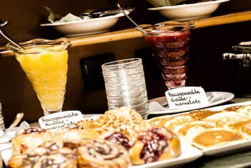 a table with two drinks and plates of pastries at Hotel Dreiflüssehof in Passau