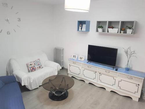 uma sala de estar com uma televisão e um sofá em Apartamento Ca'Sara em Soria
