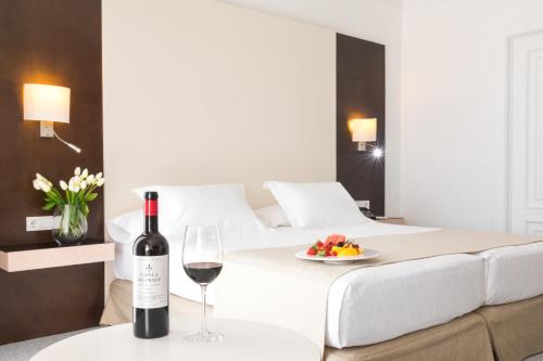 a bed with a bottle of wine and a plate of fruit at GPRO Valparaiso Palace & Spa in Palma de Mallorca