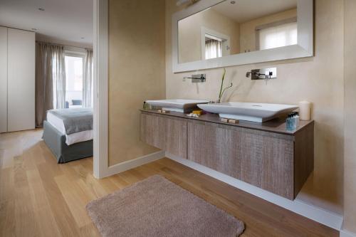 ein Bad mit einem Waschbecken, einem Spiegel und einem Bett in der Unterkunft Villa Sylvia by HMZ Villas in Vabriga