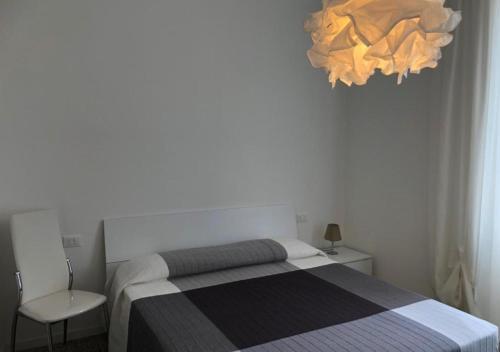 a bedroom with a bed and a chandelier at Hotel Ariston & Apartments in Varazze