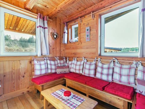 uma sala de estar com almofadas vermelhas e brancas e uma mesa em Quaint Chalet in Harreberg with Garden em Harreberg
