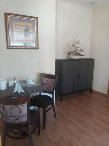 a dining room with a table and chairs and a cabinet at Hotel Garni Regent in Euskirchen