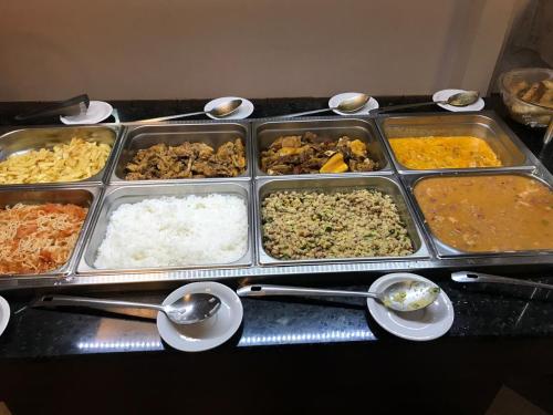 a table with several trays of different types of food at Hotel Enseada de Ponta Negra in Natal
