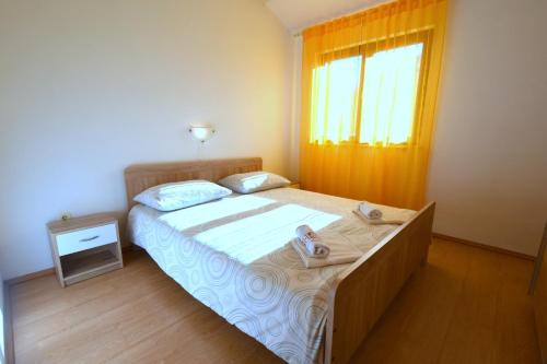 a bedroom with a large bed with shoes on it at Apartments Marinela in Njivice