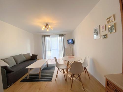 a living room with a couch and a table and chairs at Easy Apartamenty in Rzeszów