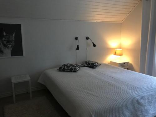 a bedroom with a bed with two pillows on it at Villa Tammikko in Tuusula
