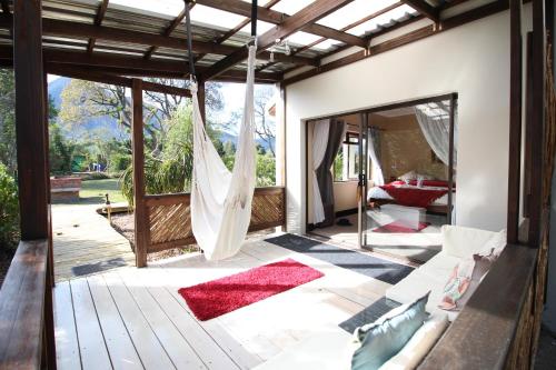 a porch with a hammock and a living room at MALI Boutique Lodge & Tube 'n Axe Budget Accommodation in Stormsrivier
