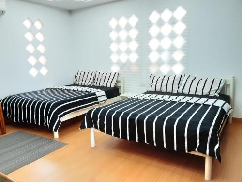 two beds sitting next to each other in a room at Maena Water Chalets in Tumpat