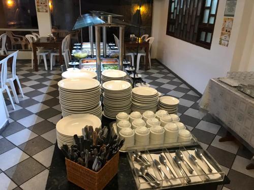 a table with white plates and utensils in a restaurant at Hotel Enseada de Ponta Negra in Natal