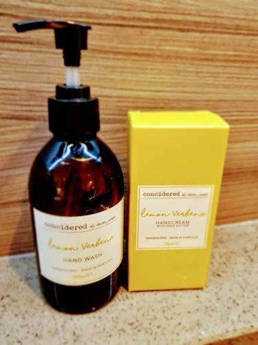 a bottle of soap next to a yellow box at Cocoa Lily - River fronted studio with secure parking in York
