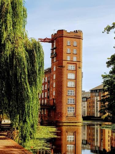 a tall brick building with a crane on top of it at Cocoa Lily - River fronted studio with secure parking in York