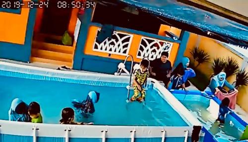 a boy in a toy swimming pool with people at Maena Water Chalets in Tumpat