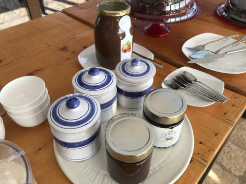 une table avec une assiette sur laquelle sont posés des bocaux de nourriture dans l'établissement Torre di Baratti Bio Resort, à Populonia