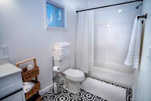 a white bathroom with a toilet and a shower at Downtown View Cozy 2BR1BA Home Sleeps 8 in San Antonio