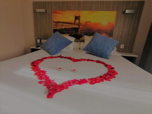 a heart made out of roses on a bed at Hôtel Saphir Lyon in Lyon