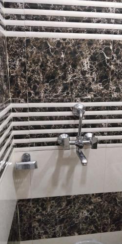 a bathroom with a sink and a shower with a faucet at C N Comforts Hotel & Dormitory in Lucknow