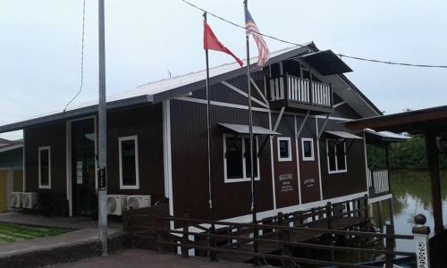 a black house with a flag on the side of it at Maena Water Chalets in Tumpat