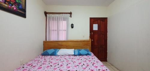 um quarto com uma cama e uma porta de madeira em Hotel Arcos del Carmen em San Cristóbal de Las Casas