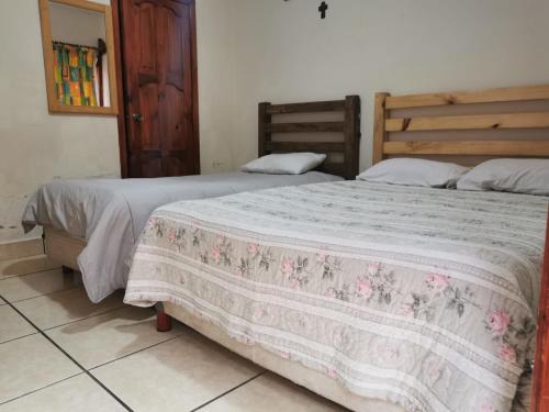 due letti uno accanto all'altro in una camera da letto di Hotel Arcos del Carmen a San Cristóbal de Las Casas