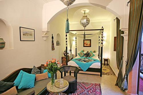 Cet appartement comprend une chambre avec un lit et un salon avec une table. dans l'établissement Riad Laora, à Marrakech