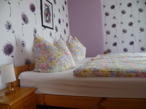 1 dormitorio con 1 cama con flores en la pared en Ferienhaus II Heyder en Elbingerode