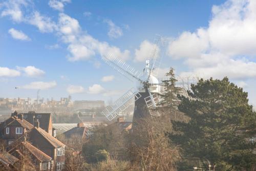 a windmill in a city with houses and trees at Windmill View Loft Apartment in York