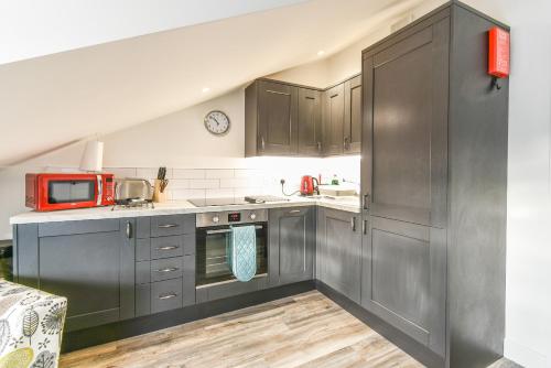 a kitchen with gray cabinets and a red microwave at Windmill View Loft Apartment in York