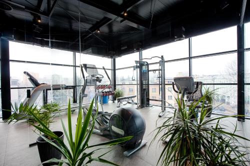 um ginásio com plantas e equipamento de exercício e janelas em Hotel Royal & Spa em Bialystok
