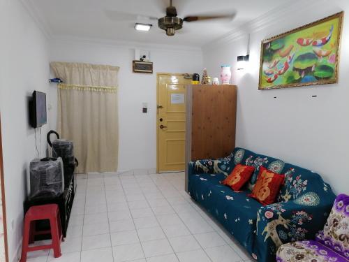 ein Wohnzimmer mit einem blauen Sofa und einer gelben Tür in der Unterkunft Elaine @ Home Stay in Kota Kinabalu