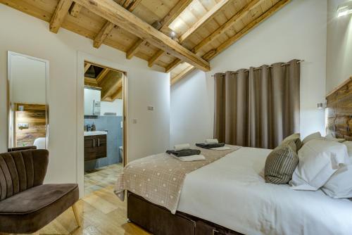 a bedroom with a large bed and a chair at Chalet Rubicon in Les Houches
