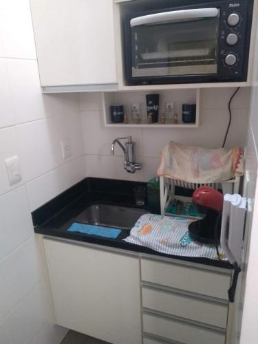 una pequeña cocina con fregadero y microondas en ÓTIMO Apto NA ZONA SUL DO RJ, en Río de Janeiro