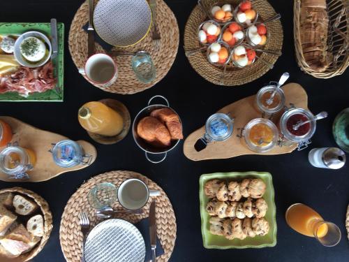 a table with plates of food and cups of coffee at Villa Cabrida in Cabrières-dʼAvignon