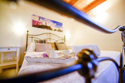 een slaapkamer met een bed en een tafel met kopjes en thee. bij Aruciméli Rural Resort in Giarratana