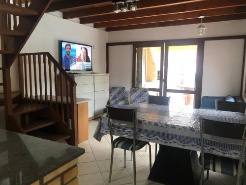 una sala da pranzo con un tavolo e una televisione di Linda casa com piscina em Bombinhas, espaço inteiro a Bombinhas