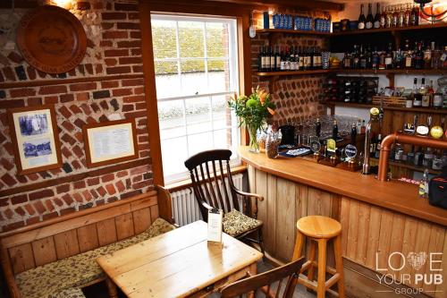 a restaurant with a wooden table and a bar at The Star and Garter in East Dean