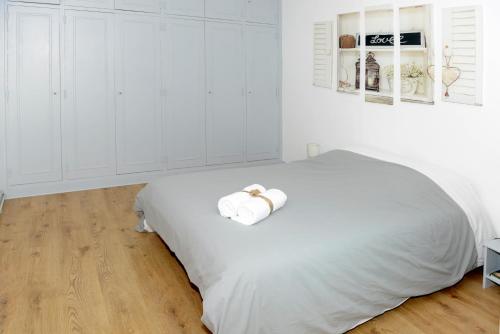 a white bedroom with a bed with towels on it at La corderie du Lude in Granville