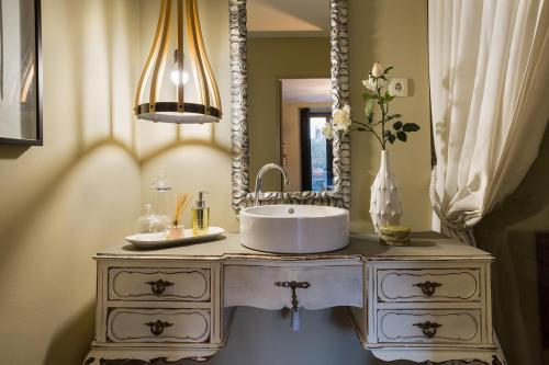 a bathroom with a white sink and a mirror at The Gallery Studios in Porto