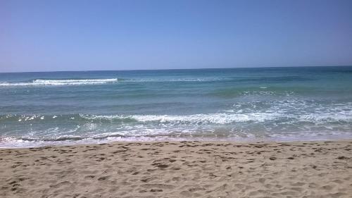 a sandy beach with the ocean in the background at Holiday Apartments Azzurro Salento in Torre Vado