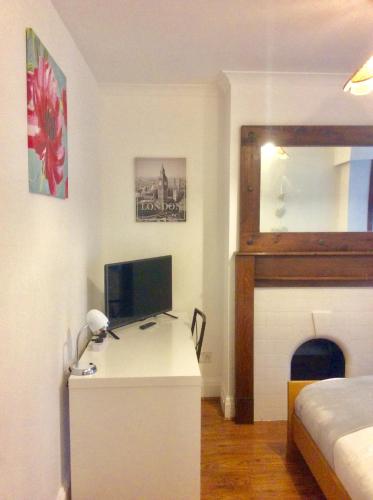 a bedroom with a desk with a computer and a bed at Gateway House in Didcot