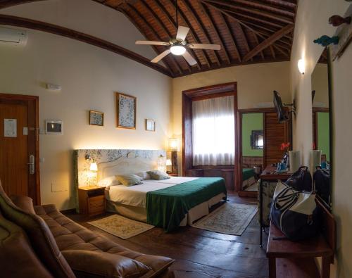 1 dormitorio con 1 cama y 1 sofá en Gara Hotel, en Garachico