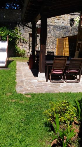 a patio with two chairs and a table in a yard at Posada Carpe Diem in Liérganes