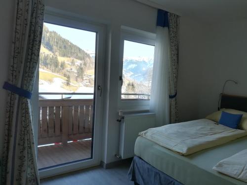 Schlafzimmer mit einem Bett und einer Glasschiebetür in der Unterkunft Apartment Waldhaus Opitz in Zell am See