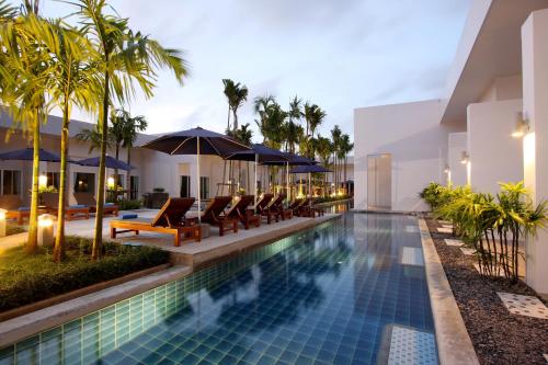 a pool at the resort with chairs and umbrellas at BLU PINE Villa & Pool Access - SHA Plus in Kata Beach