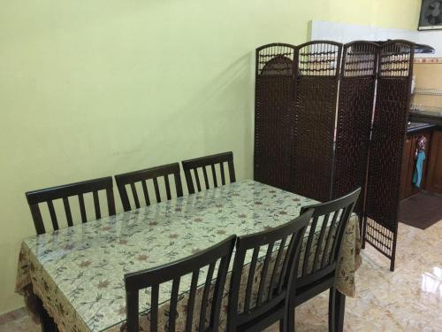 ein Zimmer mit einem Tisch und Stühlen sowie einem Tisch und einem Tisch mit einem Stuhl in der Unterkunft Pandan Home Stay in Alor Setar