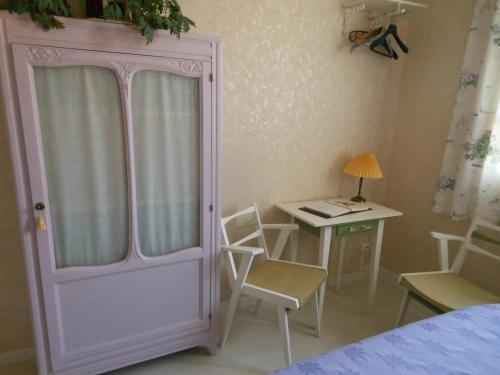 a bedroom with a pink door and a table and chairs at Au Soleil d'Albi in Albi