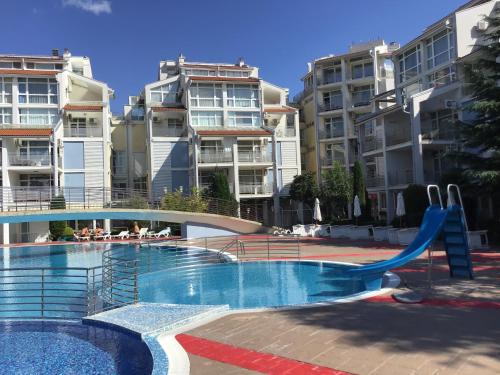 ein Pool mit Rutsche vor einigen Apartmentgebäuden in der Unterkunft Elit 2 Apartment in Sonnenstrand